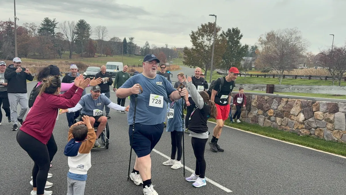 Participants and supporters cheering and high-fiving at a My Impossible race finish